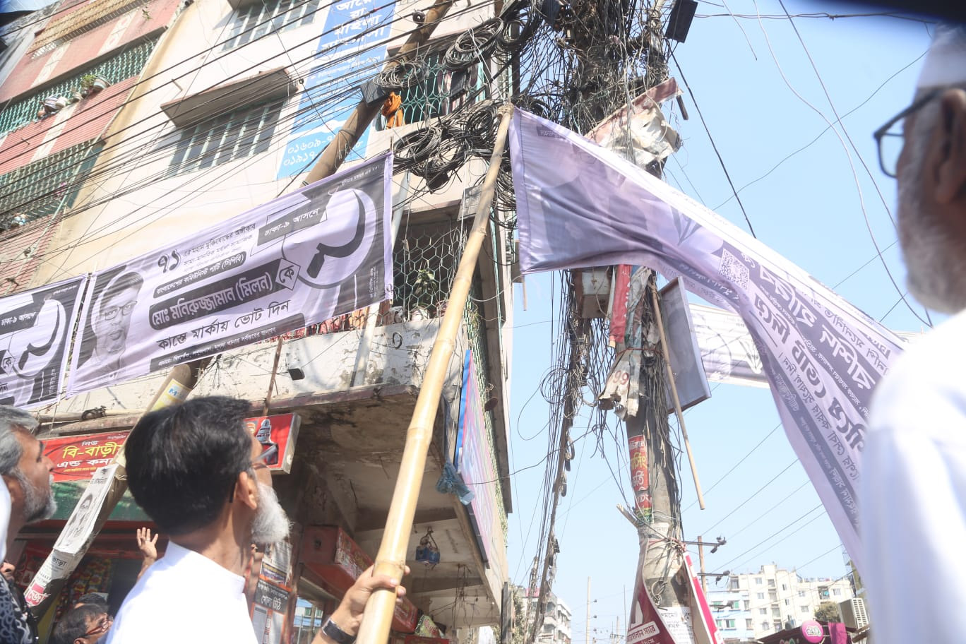 প্রচারণার ব্যানার সরিয়ে ফেলছেন হাবিবুর রশিদ হাবিব।